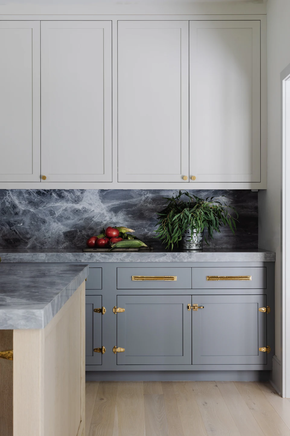 Butler's pantry with shaker cabinets, dramatic dark marble backsplash, and brass hardware in the Fairfield Transitional custom home